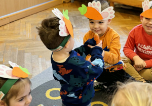 Dzieci bawią się z marchewką