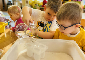 Dzieci robią eksperymenty z wodą i lodem