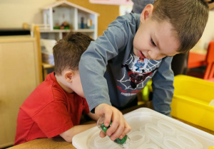 Dzieci robią eksperymenty z wodą i lodem