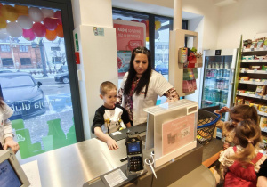 dzieci skanują na kasie produkty