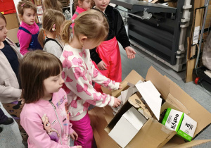 dzieci układają pudła kartonowe