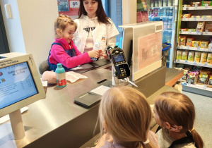 dzieci skanują na kasie produkty