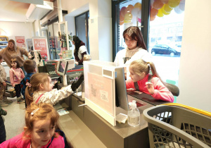 dzieci skanują na kasie produkty