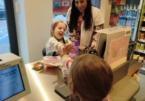 dzieci skanują na kasie produkty