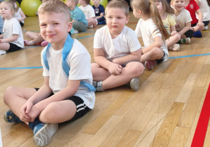 dzieci siedzą w rzędzie