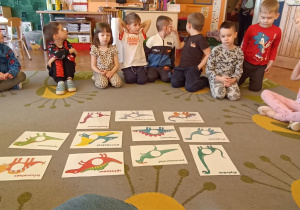 na dywanie leżą ilustracje dinozaurów