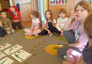 na dywanie leżą ilustracje dinozaurów