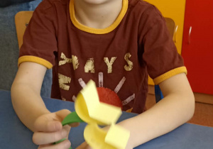 chłopiec trzyma kwiatka z papieru