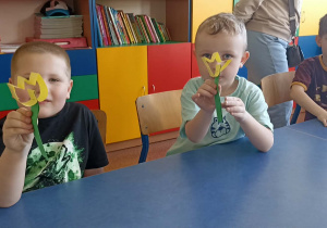 dzieci trzymają kwiatka z papieru