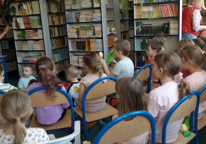 dzieci siedzą na krzesełkach