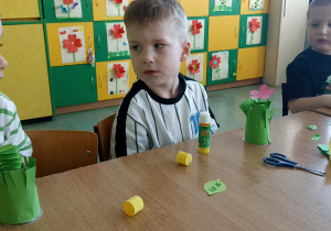 dzieci trzymają kwiatka z papieru