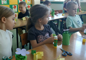 dzieci siedzą w ławkach