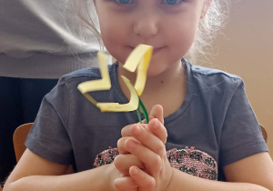 dzieci trzymają kwiatka z papieru