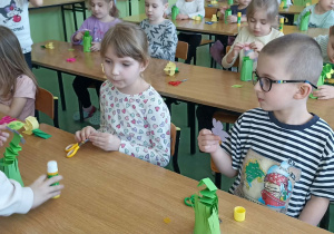 dzieci siedzą w ławkach