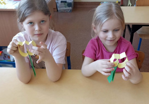 dzieci trzymają kwiatka z papieru