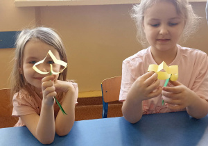 dzieci trzymają kwiatka z papieru