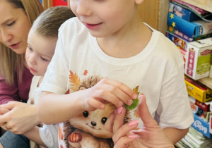 Dzieci z rodzicami wykonują koszyczki wielkanocne