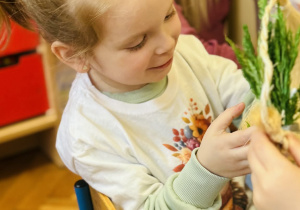 Dzieci z rodzicami wykonują koszyczki wielkanocne