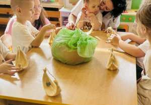 Dzieci z rodzicami wykonują koszyczki wielkanocne