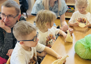Dzieci z rodzicami wykonują koszyczki wielkanocne