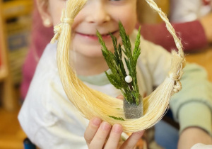 Dzieci z rodzicami wykonują koszyczki wielkanocne