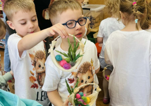 Dzieci z rodzicami wykonują koszyczki wielkanocne
