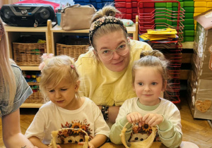 Dzieci z rodzicami wykonują koszyczki wielkanocne