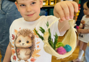 Dzieci z rodzicami wykonują koszyczki wielkanocne