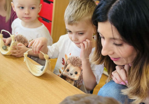 Dzieci z rodzicami wykonują koszyczki wielkanocne