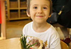 Dzieci z rodzicami wykonują koszyczki wielkanocne