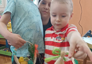 dzieci z rodzicami pokazują swój koszyczek