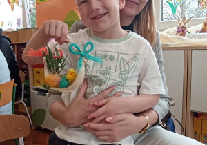 dzieci z rodzicami pokazują swój koszyczek