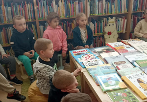 dzieci siedzą przy stole z książkami