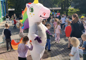 dzieci tańczą na tarasie wokół jednorożca
