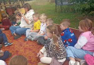 dzieci siedzą w przyczepie do traktora