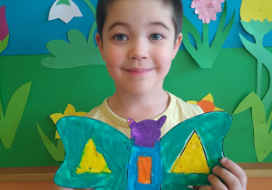 Chłopiec prezentuje motyla z plasteliny