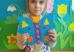 Dziewczynka prezentuje motyla z plasteliny
