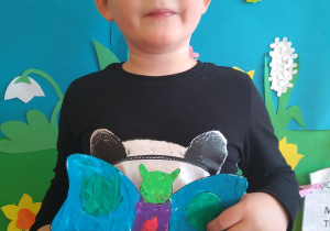 Chłopiec prezentuje motyla z plasteliny