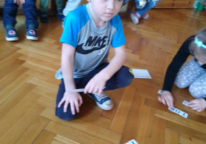 Dzieci układają kartki z literami