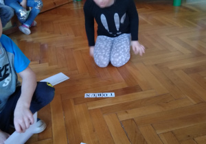 Dzieci układają kartki z literami