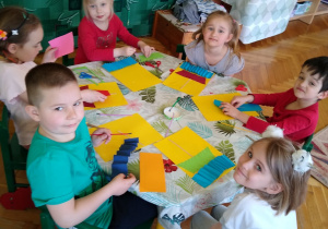 Dzieci przyklejają kolorowe kawałki papieru