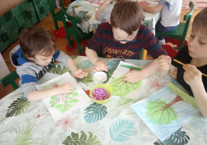 Dzieci przyklejają kulki z bibuły.