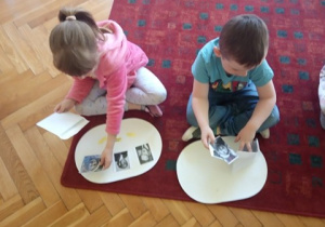 Dzieci układają fotografie W. Chotomskiej, J. Tuwima i J. Brzechwy.
