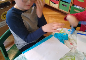 Dziecko przykleja bibułę