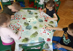 Dzieci wykonują pracę plastyczną o biedronkach.