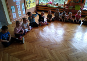 Dzieci siedzą na podłodze