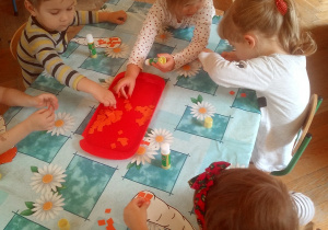 dzieci wyklejają kontur papieren kolorowym