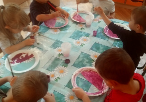 dzieci malują papierowe taterzyki wycięte w kształcie koszyka