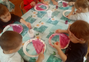 dzieci malują papierowe taterzyki wycięte w kształcie koszyka