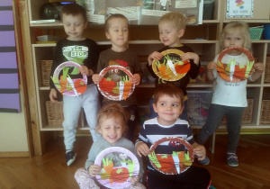 dzieci trzymają w ręku koszyk z warzywami z kolorowego papieru